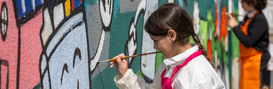 School child painting the 'Our Imagined Future' mural
